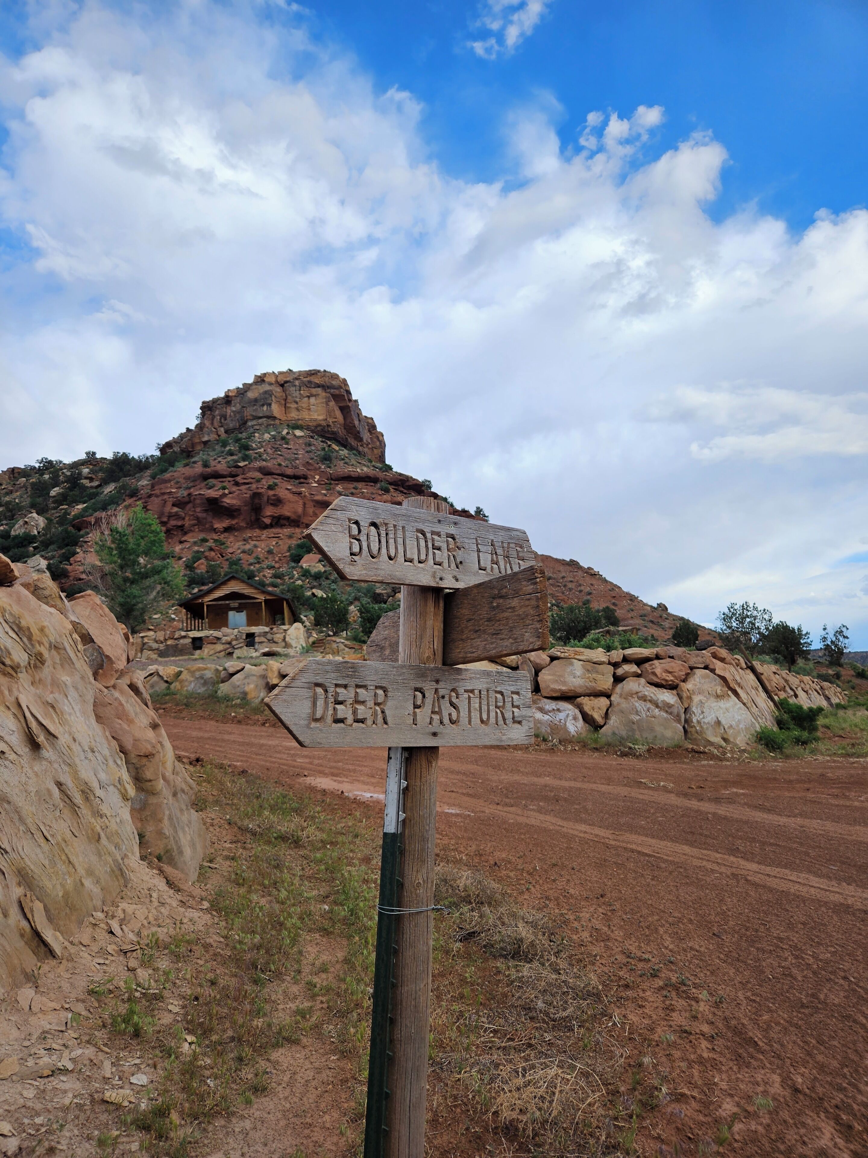 A wooden signpost with directions to 'BOULDER LAKE' and 'DEER PASTURE'.