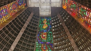 A large, open atrium with a grid-like ceiling structure and colorful stained glass panels on the walls. - Lapinha 40 graus (Rio de Janeiro)