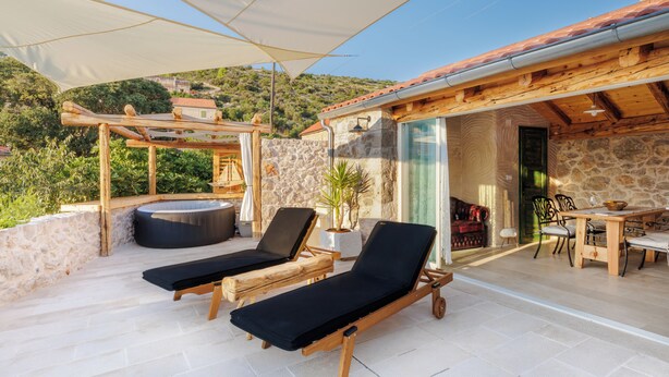 Une terrasse sur le toit équipée de deux chaises longues, d’un jacuzzi et d’un espace repas avec une table et des chaises.