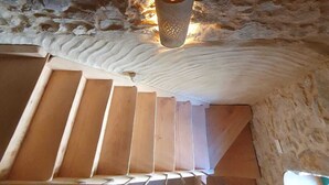 Un intérieur en pierre avec un escalier en bois menant à un niveau supérieur.