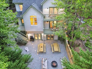 Une maison à deux étages dotée d’un patio couvert, d’un espace salon extérieur et d’un foyer.