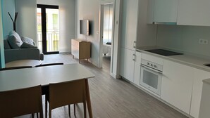 A modern apartment with a dining area, kitchen, and a living room with a sofa and TV. - Perfect, Modern Studio In The Heart Of Alicante (Alicante (Alacant))