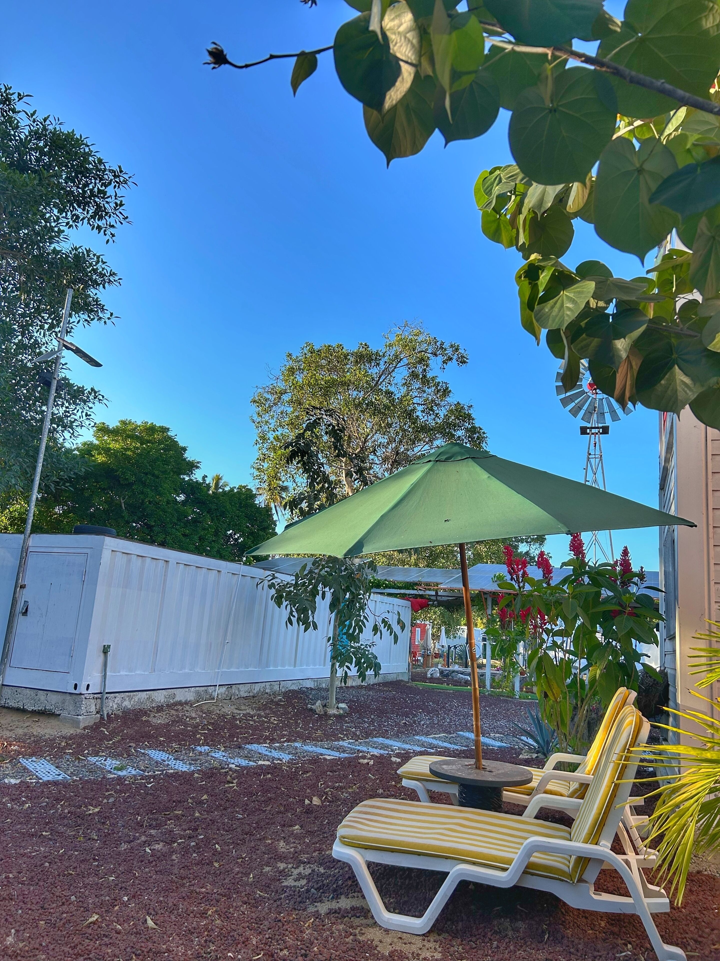 A patio area with a windmill, outdoor seating, and a white fence.
