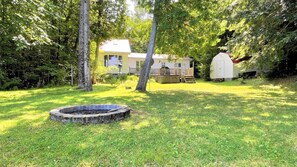 A house with a fenced yard, a wooden deck, and a small shed. - Great Value! Lasswade Lake Cottage Rental (North Kawartha)