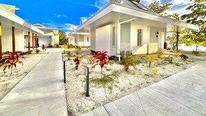 A row of modern, single-story houses with a covered walkway and landscaped gardens. - Niu Beach Hotel Moorea (Moorea-Maiao)