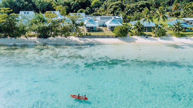 A coastal resort with clear turquoise waters, a sandy beach, and several villas with blue roofs. - Niu Beach Hotel Moorea (Moorea-Maiao)