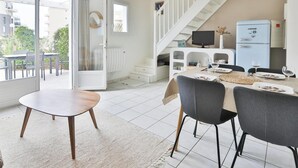 Una cocina moderna con comedor, una escalera y vistas al exterior.