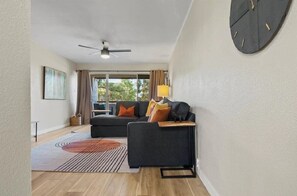 Relax in this stylish living room with a sofa, coffee table, and ceiling fan.