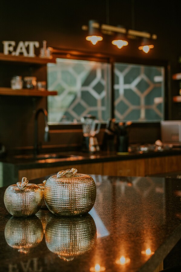 A kitchen counter with decorative ceramic pumpkins and a reflective surface.
