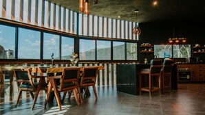 A modern kitchen with a large island, bar seating, and a view of the outdoors. - K NAJ Community (San Miguel de Allende)