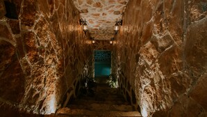 A stone staircase with a patterned ceiling and wall sconces. - K NAJ Community (San Miguel de Allende)