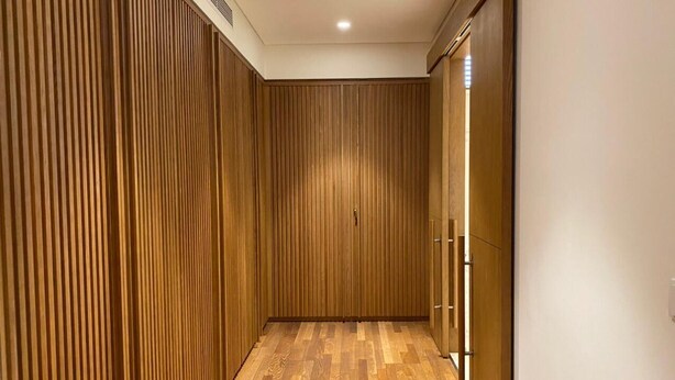 Un couloir aux murs recouverts de lambris en bois et doté d’un plancher en bois.