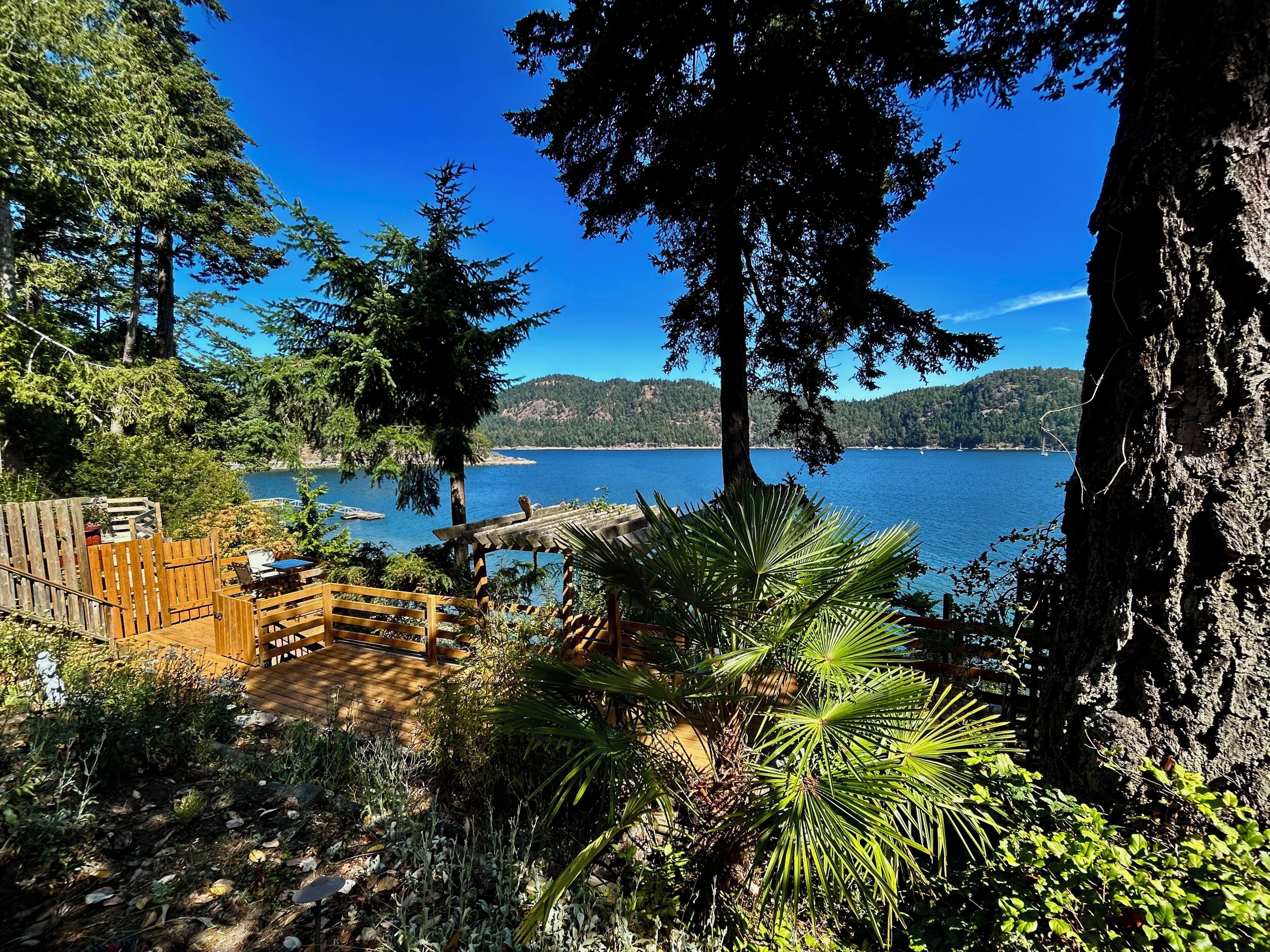 A wooden deck with a view of a lake and mountains.