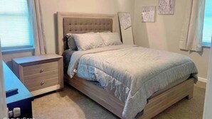 Une chambre à coucher avec un lit, une table de chevet et une commode.