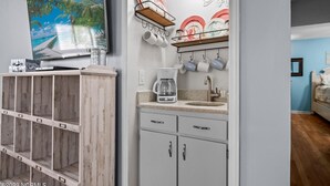 A kitchen with a coffee maker, a sink, and a dish rack. - Calabash ready
 (Calabash)