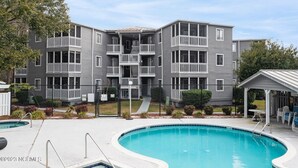 A multi-story residential building with balconies, a swimming pool, and a covered seating area. - Calabash ready
 (Calabash)