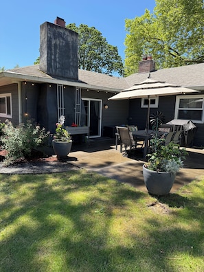 A house with a patio, outdoor seating, and potted plants.