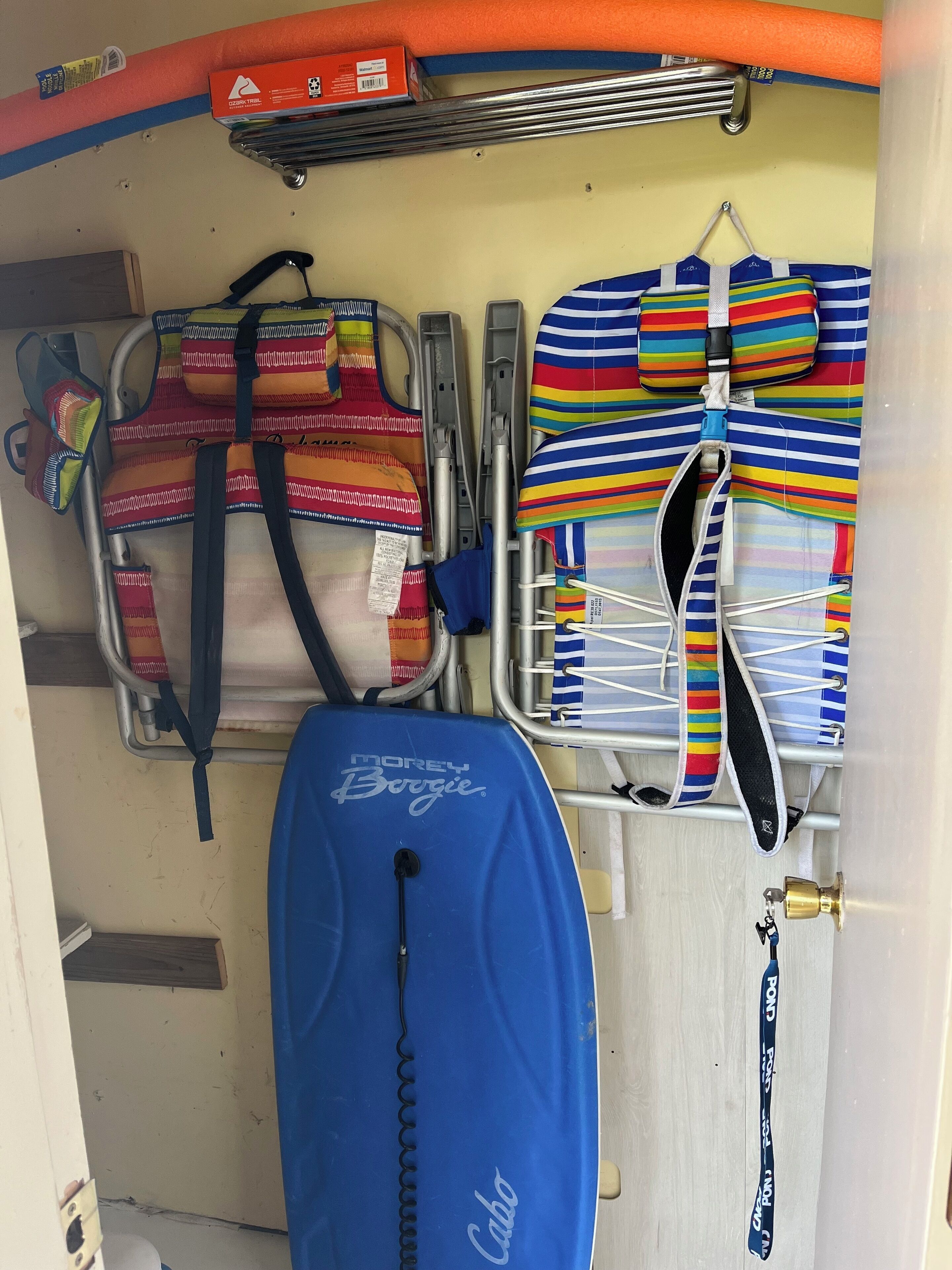 Un espace de rangement contenant divers sacs et une valise bleue.