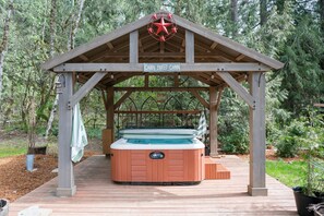 A wooden gazebo with a hot tub labeled "Cabin Sweet Cabin" in a forested area. -  Cozy and Dog friendly retreat by Relaxing Creek & Hot tub by Lake Cushman (Hoodsport)