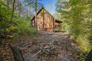 A rustic cabin with a fire pit and outdoor seating. - Creekside Serenity | Hocking Hills, Creek, Hot Tub (Logan)