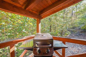 A charcoal grill under a wooden pavilion with a view of a forest. - Creekside Serenity | Hocking Hills, Creek, Hot Tub (Logan)
