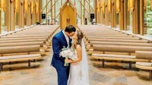 Une cérémonie de mariage dans une église dotée d’une haute voûte en bois et de bancs disposés en rangées.
