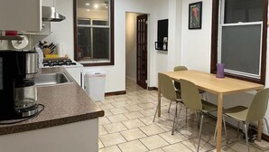 Une cuisine compacte équipée d’une machine à café, d’un évier et d’une table à manger avec des chaises.