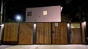 Propiedad resguardada por un muro con un edificio moderno y un letrero que dice "Green Turtle".
