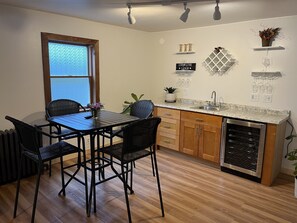 Een moderne keuken met een eettafel, stoelen, een inbouwoven en een raam met uitzicht.