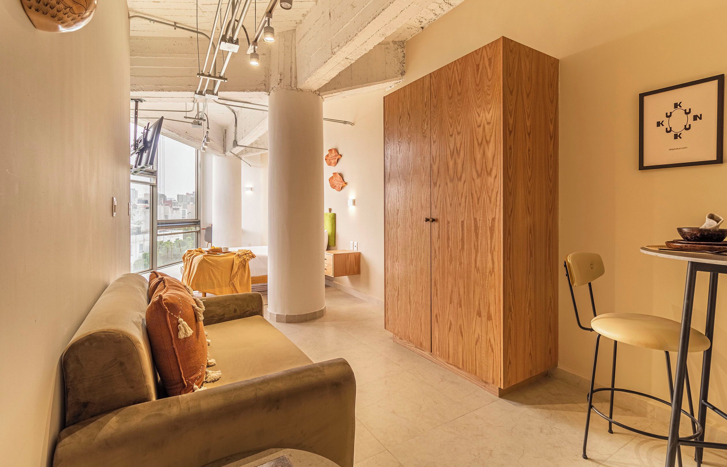 Ein modernes Interieur mit einem Holzschrank, einer Couch und einem Essbereich.