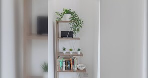 A bookshelf with books, a bowl, and small plants. - Fantastically Located 1BD Flat in Islington (London)