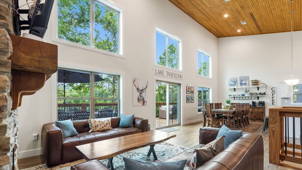 A spacious living area with a fireplace, large windows, and a dining area.