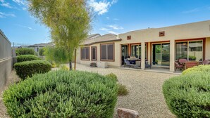 A modern building with a patio area, outdoor seating, and well-maintained landscaping. - Resort Pools + More Perks! 55 + Goodyear Escape (Goodyear)