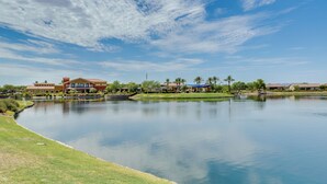 A large building with a swimming pool, surrounded by greenery and palm trees. - Resort Pools + More Perks! 55 + Goodyear Escape (Goodyear)