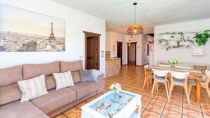 Un salon comprenant un canapé, une table basse et un coin repas avec des chaises et une table.