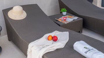 Relax in a tranquil outdoor lounge with a comfortable sofa, magazine, and sunglasses at the ready.