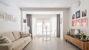 A modern living room with a sofa, a coffee table, and a TV on a wooden cabinet. - UR-NEST San Gervasio, charming one-bedroom apartment (Bologna)