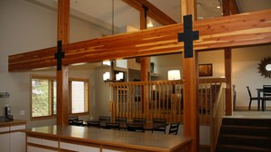 A spacious kitchen with wooden beams, a dining area with chairs, and a staircase leading to another level. - Deluxe Three Bedroom Condo. AMAZING VIEWS. On bus route. Pet friendly. (Breckenridge)