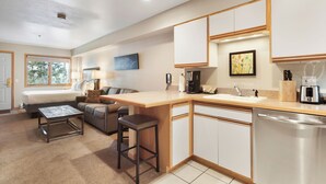 A modern kitchen with a wooden countertop, built-in cabinets, and a stainless steel dishwasher. - Studio Condo. AMAZING VIEWS. On bus route. Pet friendly. (Breckenridge)