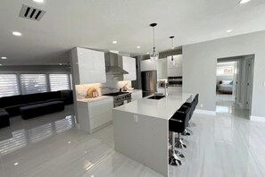 Enjoy cooking in this well-equipped kitchen with a central island and sink, stove, and seating area nearby.