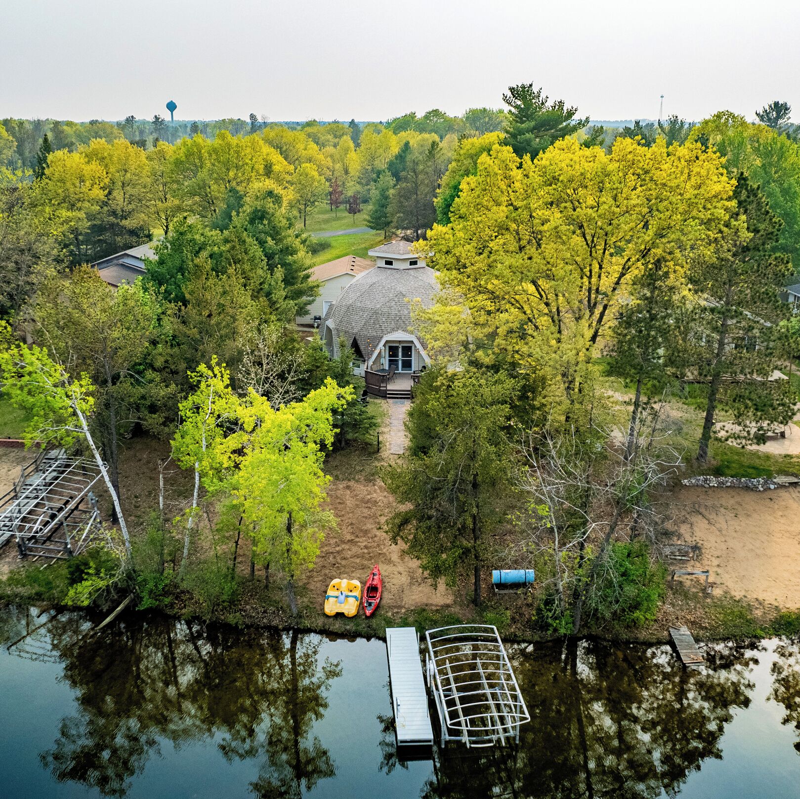 A house surrounded by trees and a body of water.