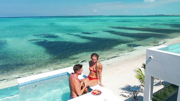 Zona junto a la piscina con vista al océano y a la playa.