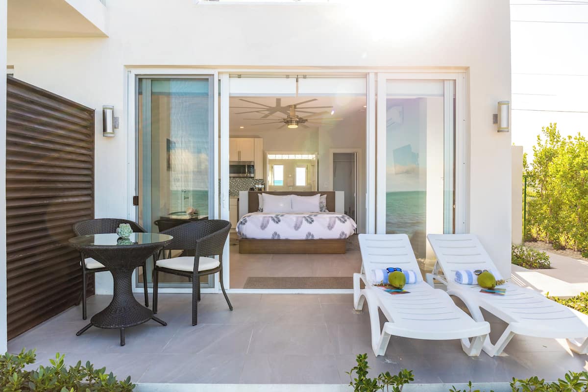 Een moderne, open woonkamer met een balkon, een eettafel en lounge fauteuils.