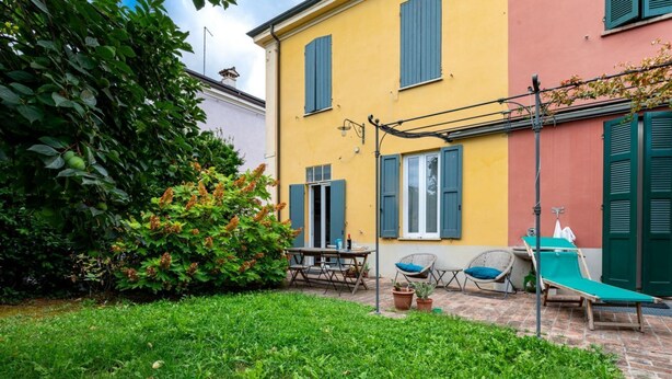 A courtyard with a table, chairs, and a lounge chair. - Wonderful villa, divided over two floors, with garden. Independent entrance.Basement with laundry area.It comfortably accommodates 6 guests in 100 m2 of space with three bedrooms and two bathrooms.LIVING AREA: living room with double sofa bed, 32 TV, si (Parma)