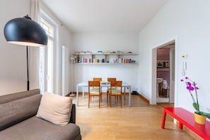 A modern living room with a sofa, dining table, chairs, a red bench, and a bookshelf. - Wonderful villa, divided over two floors, with garden. Independent entrance.Basement with laundry area.It comfortably accommodates 6 guests in 100 m2 of space with three bedrooms and two bathrooms.LIVING AREA: living room with double sofa bed, 32 TV, si (Parma)