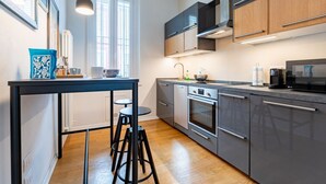 A modern kitchen with a central island, stainless steel appliances, and a window providing natural light.