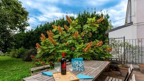 A wooden table with a bottle of wine, two glasses, and a blue floral placemat. - Wonderful villa, divided over two floors, with garden. Independent entrance.Basement with laundry area.It comfortably accommodates 6 guests in 100 m2 of space with three bedrooms and two bathrooms.LIVING AREA: living room with double sofa bed, 32 TV, si (Parma)