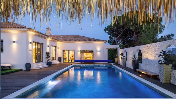 A swimming pool with a wooden deck, a stone wall, and a building with a tiled roof. - Stunning!! - Casa Chameleon - Sleeps 14 - Close to Quinta Do Lago & Vale Do Lobo (Faro)
