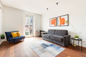 A modern living room with a sofa, a coffee table, a rug, and two framed artworks on the wall.