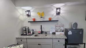 A kitchen with a coffee maker, toaster, and a sign about star ratings. - Modern Oasis near everything. (Nashville)